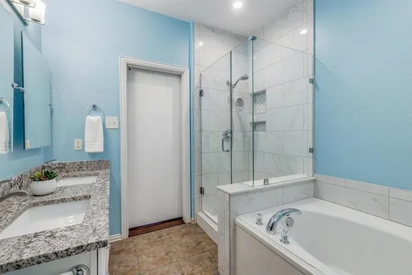 a bathroom with a granite countertop tub sink and mirror