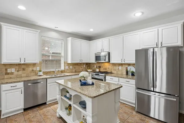 a kitchen with a sink a refrigerator a stove and cabinets