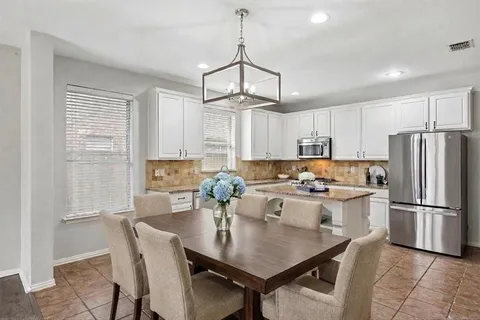 a kitchen with refrigerator cabinets dining table and chairs