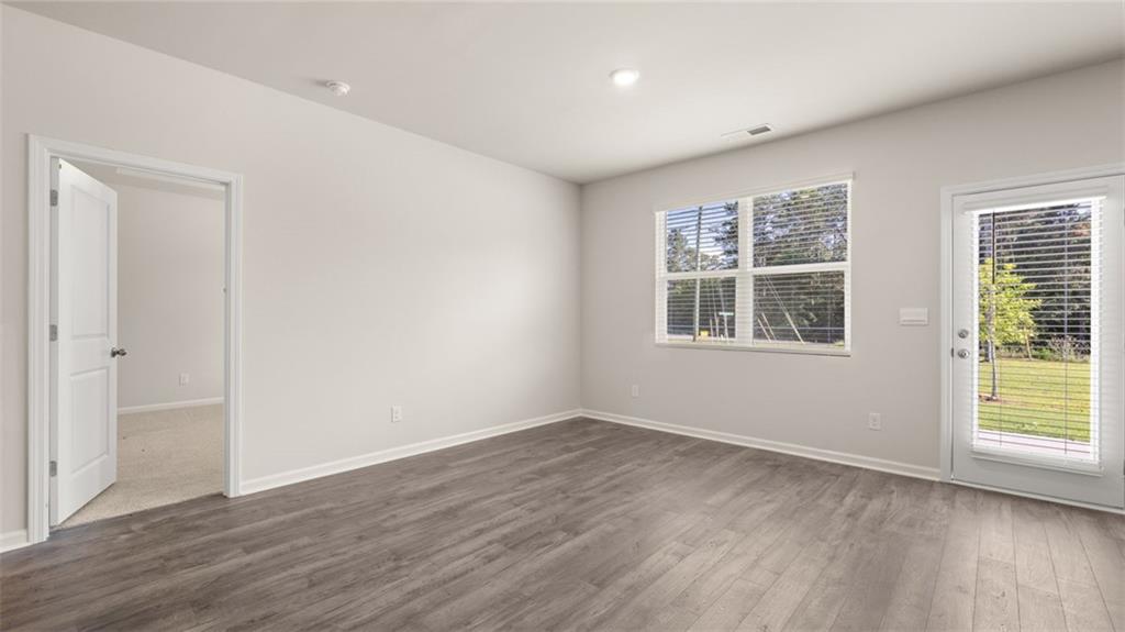 216 Cattle Drive Perry, GA 31069 - Photo 11 of 32 a view of an empty room with wooden floor and a window