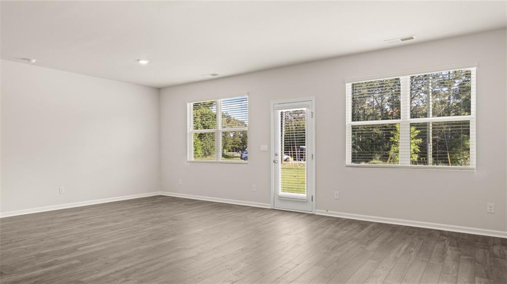 216 Cattle Drive Perry, GA 31069 - Photo 14 of 32 an empty room with wooden floor and windows