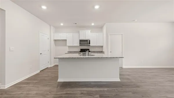 a kitchen with stainless steel appliances granite countertop a stove a sink and a microwave