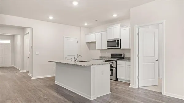 a kitchen with stainless steel appliances granite countertop a stove a sink and a refrigerator