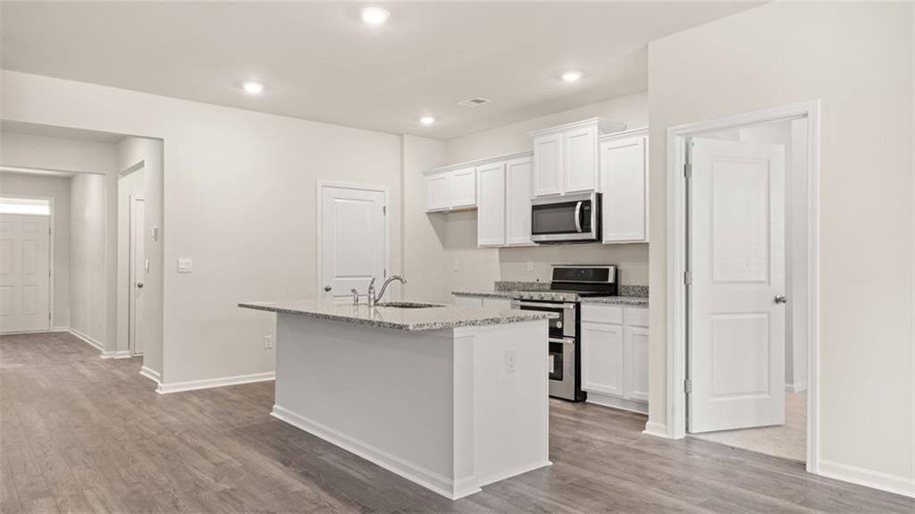 216 Cattle Drive Perry, GA 31069 - Photo 7 of 32 a kitchen with stainless steel appliances granite countertop a stove a sink and a refrigerator