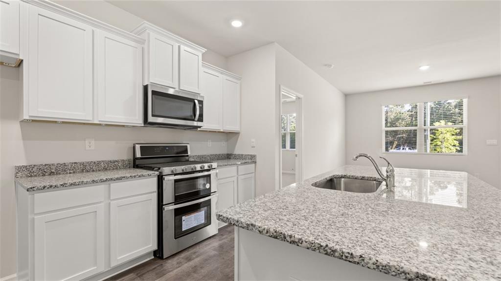 216 Cattle Drive Perry, GA 31069 - Photo 8 of 32 a kitchen with granite countertop a stove sink and microwave