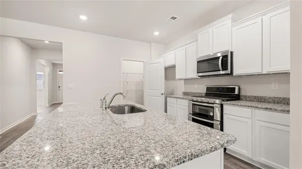 a kitchen with granite countertop a sink and steel appliances