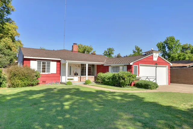 a front view of a house with a yard and potted plants
