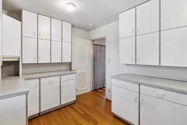 a kitchen with white cabinets and sink