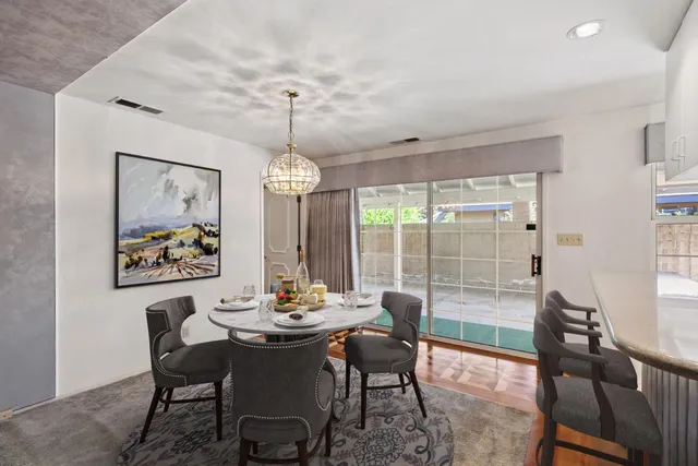 a view of a dining room with furniture wooden floor and a chandelier
