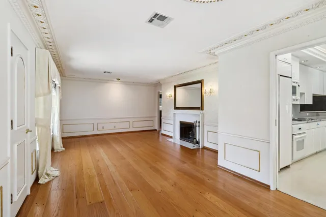 a view of empty room with wooden floor and fireplace