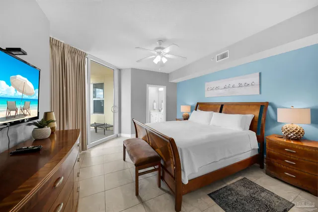 a bedroom with a bed and a flat tv screen on dresser