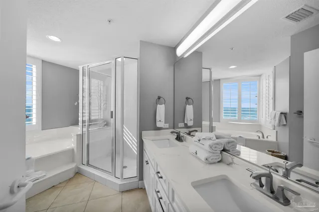 a bathroom with a double vanity sink mirror and shower