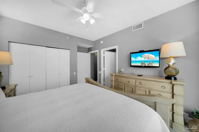 a bedroom with a bed and a flat tv screen on dresser