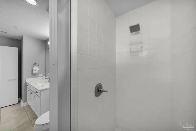 a bathroom with a granite countertop sink a toilet and shower