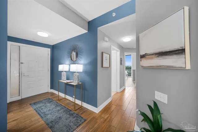 a view of a hallway with wooden floor and a bathroom