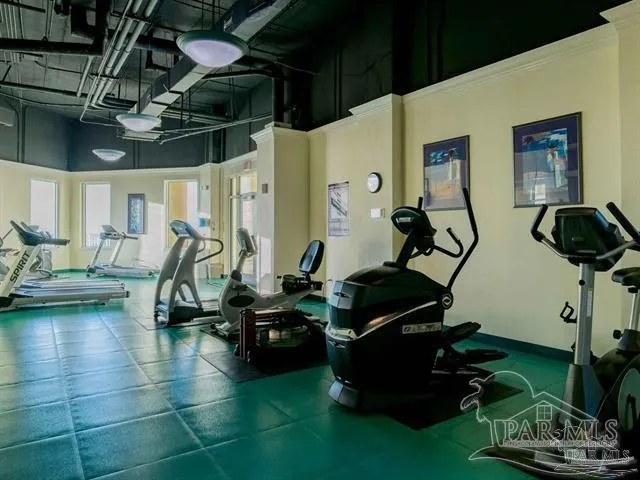 a room with gym equipment and wooden floor