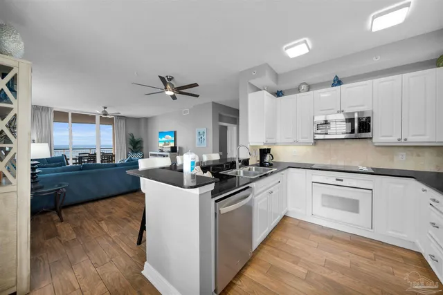 a kitchen with kitchen island granite countertop a sink cabinets and stainless steel appliances
