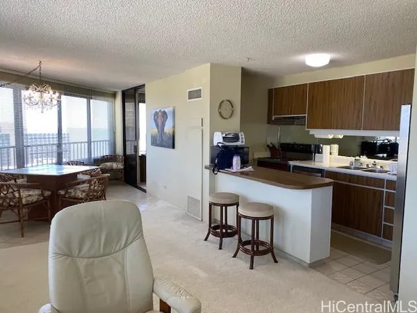 a living room with stainless steel appliances furniture a flat screen tv and a large window