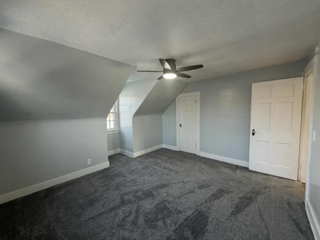 an empty room with a ceiling fan and a window