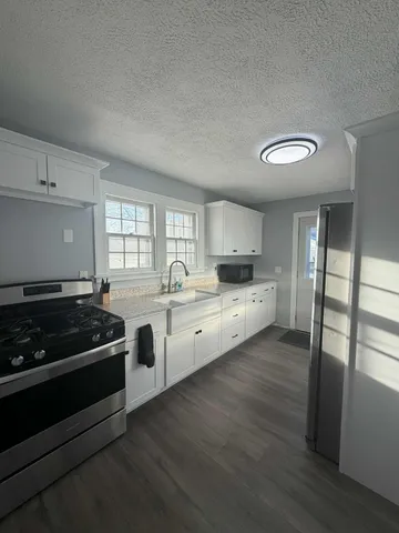 a kitchen with stainless steel appliances granite countertop a stove and white cabinets
