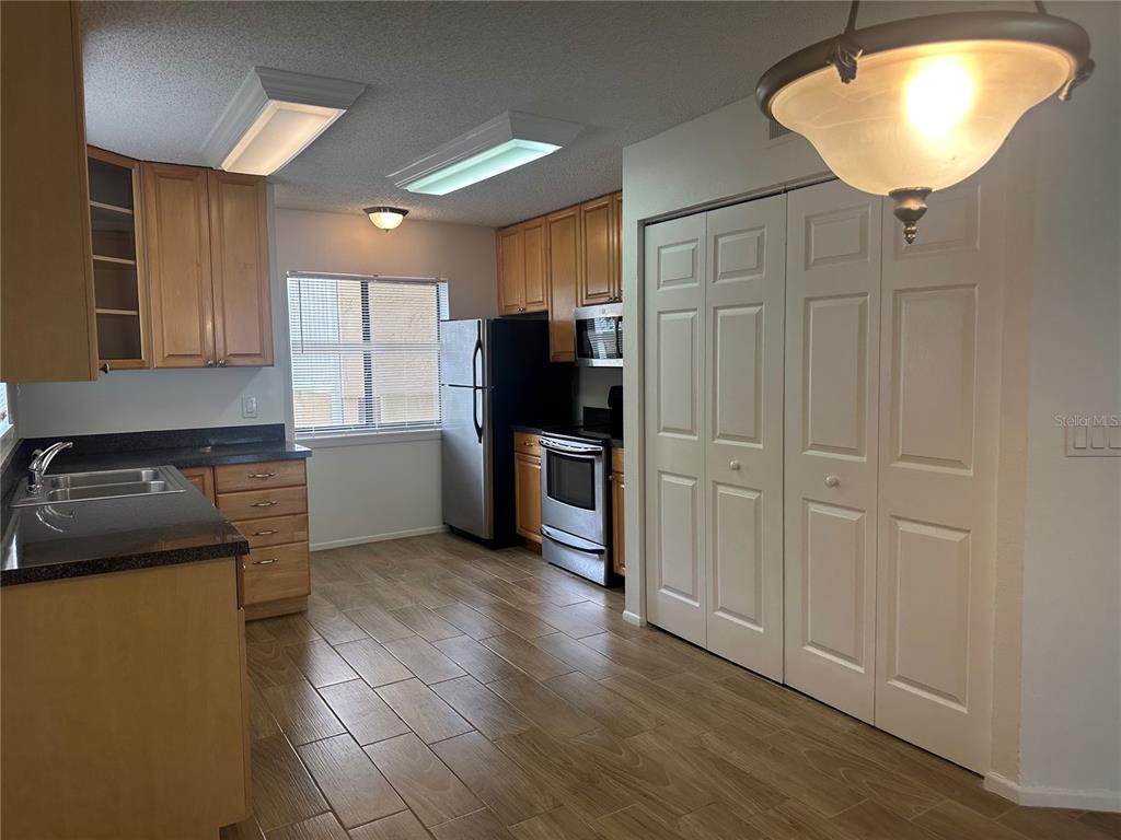 1550 South Belcher Road, Unit 412 Clearwater, FL 33764 - Photo 8 of 40 a kitchen with granite countertop a refrigerator and a sink