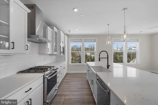a kitchen with stainless steel appliances a sink stove and cabinets