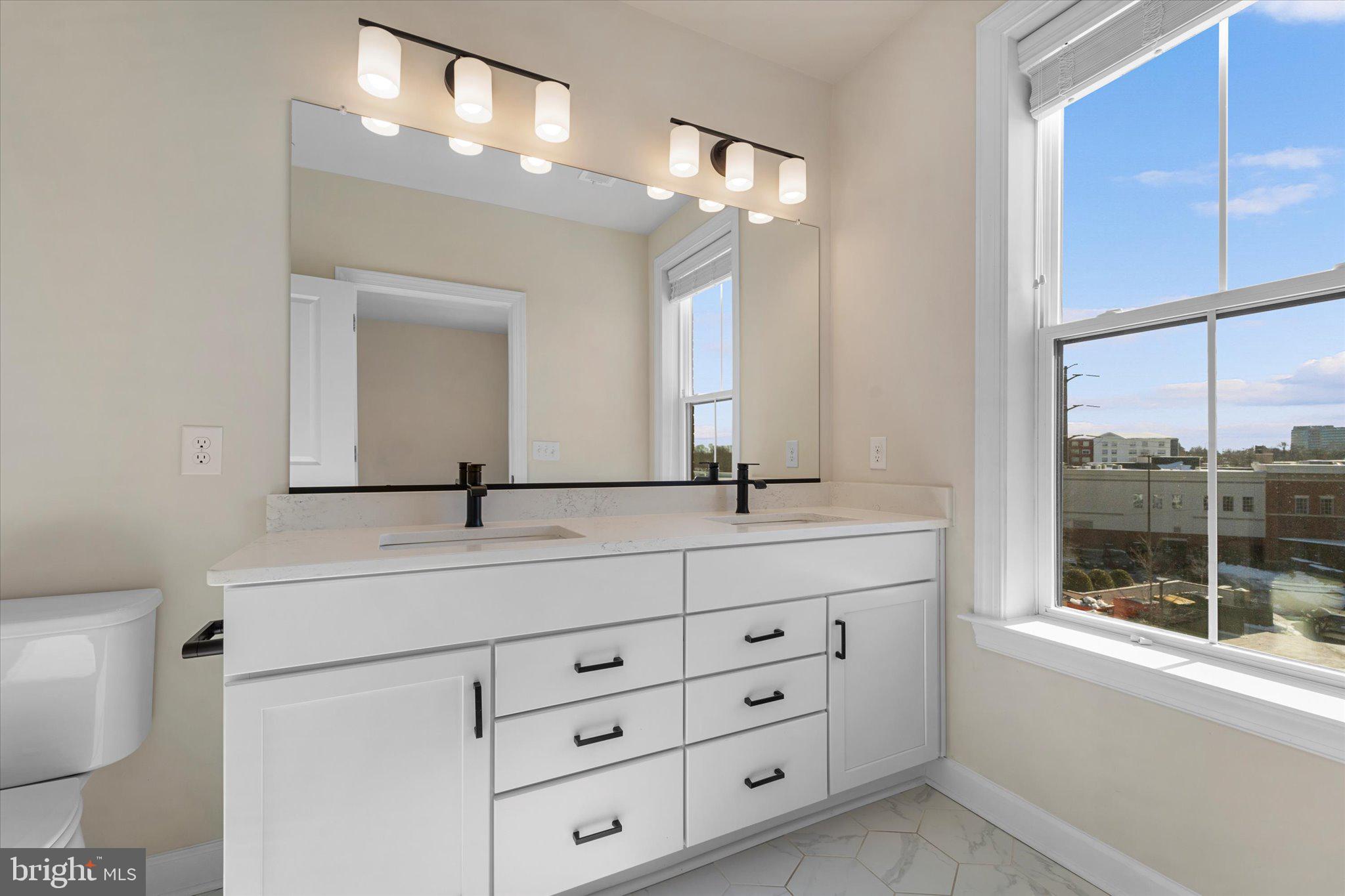 3927 Fair Ridge Drive, Unit 409 Fairfax, VA 22033 - Photo 17 of 37 a bathroom with a double vanity sink and a mirror