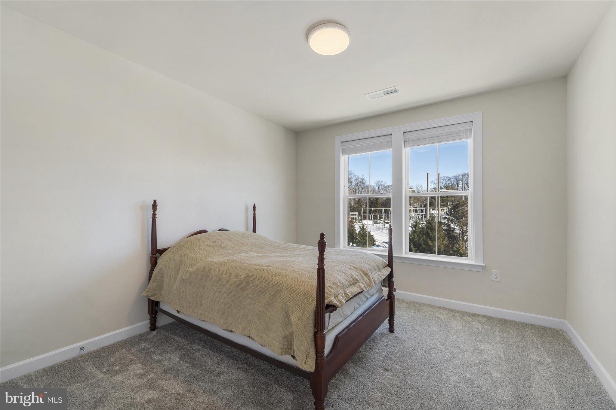 3927 Fair Ridge Drive, Unit 409 Fairfax, VA 22033 - Photo 19 of 37 a bed sitting in a bedroom next to a window