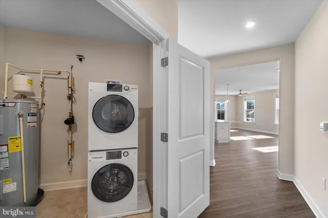 a view of an empty room with wooden floor and entrance