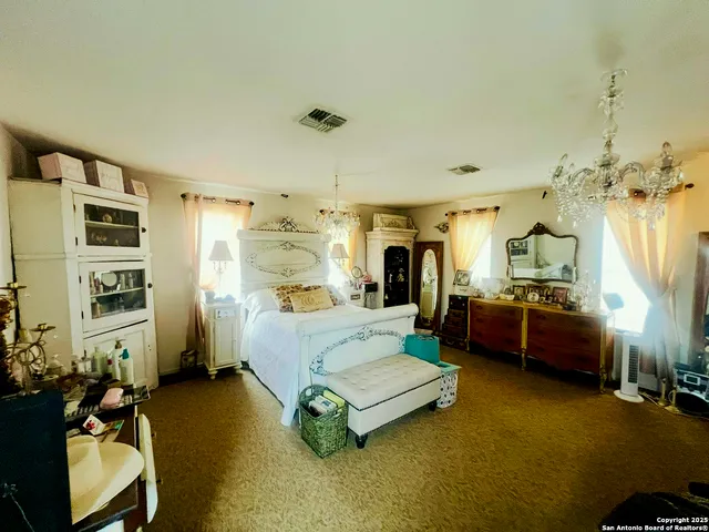 a spacious bedroom with a bed and a dresser