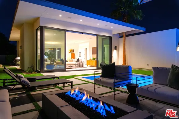 a living room with furniture a rug and a floor to ceiling window