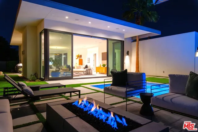 a living room with furniture a rug and a floor to ceiling window