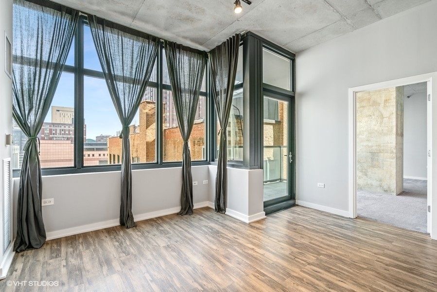 235 West Van Buren Street, Unit 1502 Chicago, IL 60607 - Photo 11 of 30 an empty room with wooden floor and windows