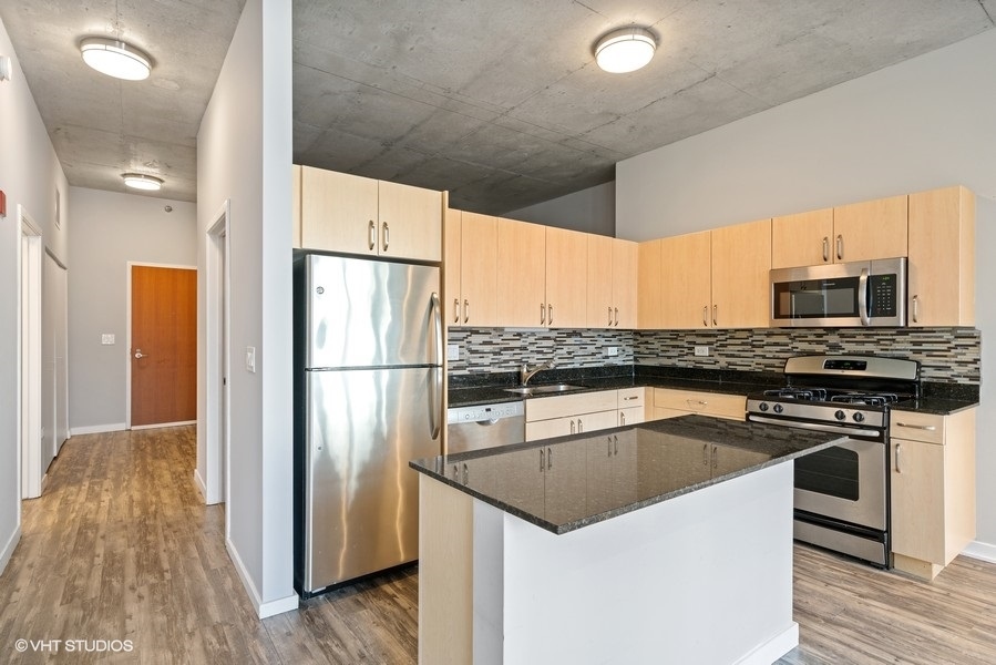 235 West Van Buren Street, Unit 1502 Chicago, IL 60607 - Photo 13 of 30 a kitchen with a sink a microwave a refrigerator and cabinets