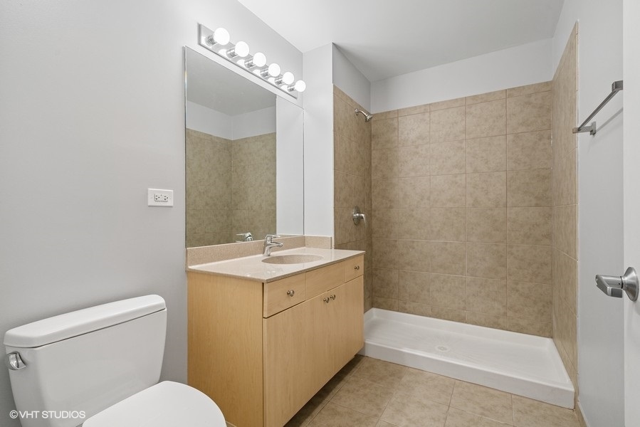235 West Van Buren Street, Unit 1502 Chicago, IL 60607 - Photo 21 of 30 a bathroom with a sink a toilet and shower