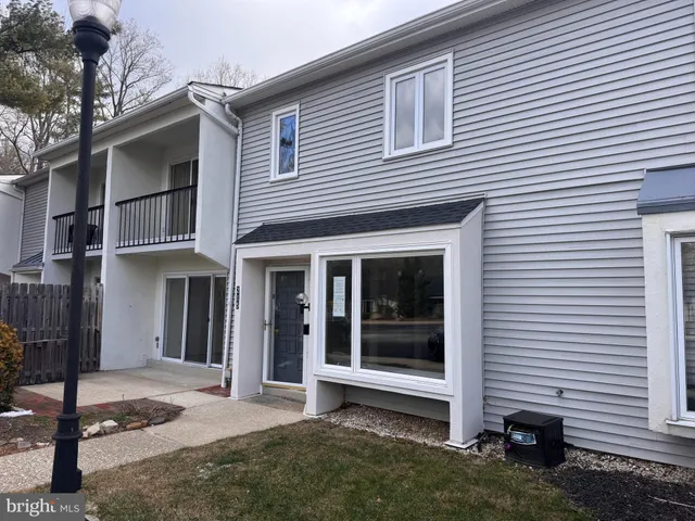 a view of a house with a yard and large tree