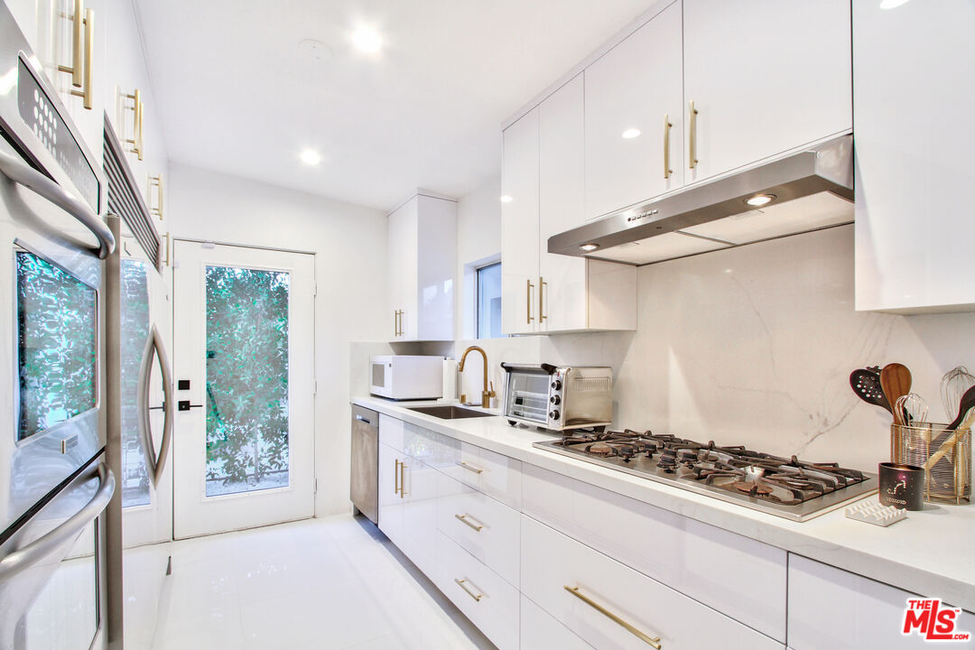 678 South Thornhill Road Palm Springs, CA 92264 - Photo 10 of 21 a kitchen with stainless steel appliances granite countertop a stove and a sink
