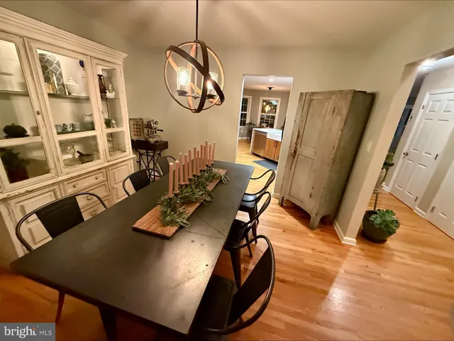 a view of a dining room with furniture a chandelier and wooden floor