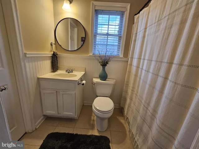 a bathroom with a toilet a sink and a mirror