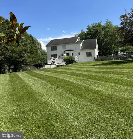 a front view of a house with a garden and trees