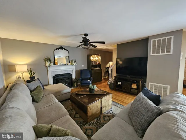 a living room with furniture a flat screen tv and a fireplace