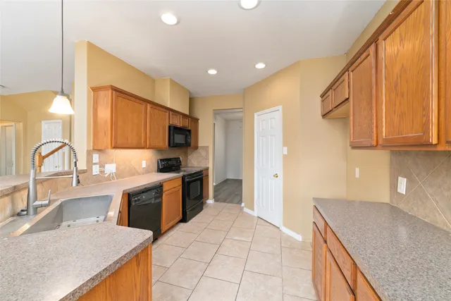 a large kitchen with stainless steel appliances granite countertop a sink and cabinets