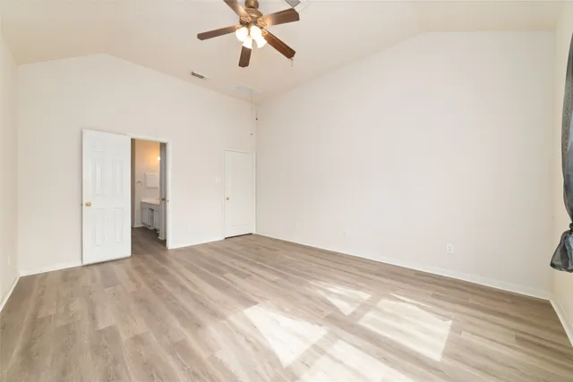 a view of empty room with wooden floor