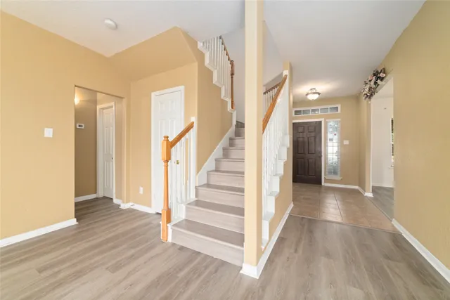 a view of a hallway with wooden floor and entryway