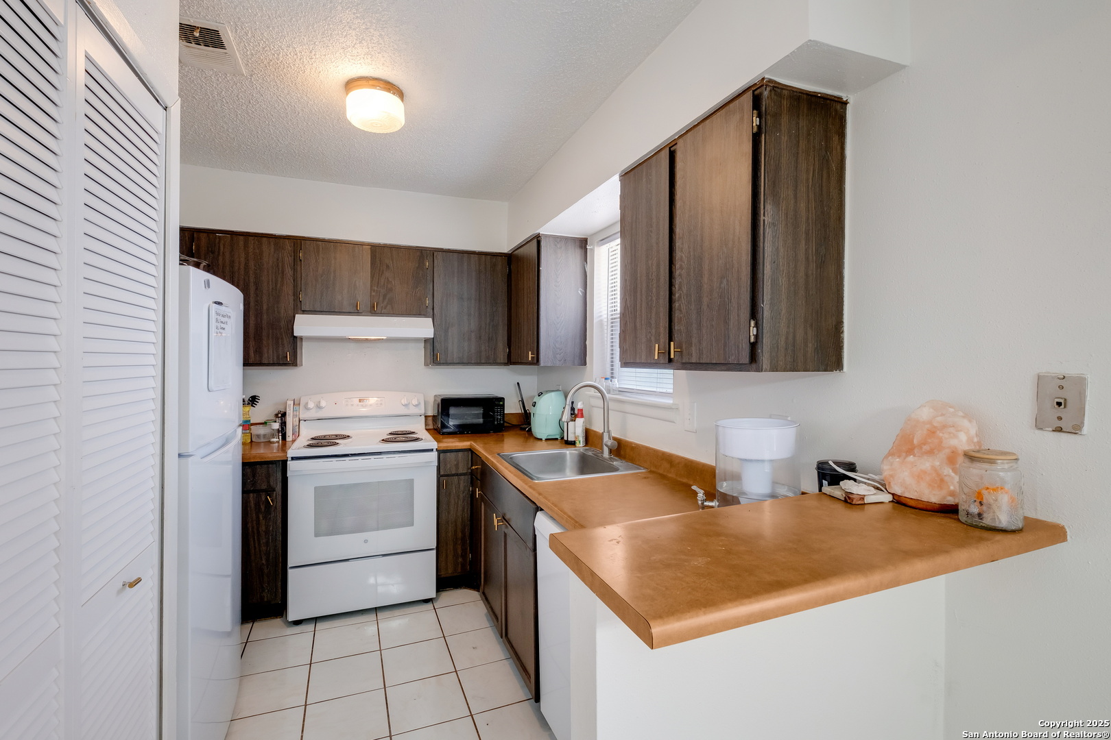 923 Vance Jackson Road, Unit 708 San Antonio, TX 78201 - Photo 6 of 18 a kitchen with stainless steel appliances granite countertop a sink stove refrigerator and cabinets
