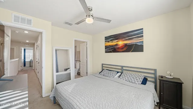 a bedroom with a large bed and a flat tv screen on dresser