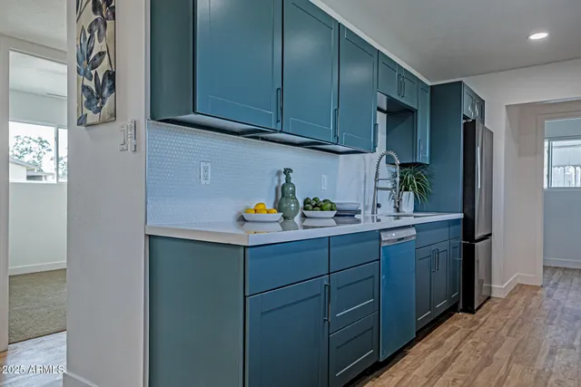 a kitchen with a sink a cabinets and wooden floor