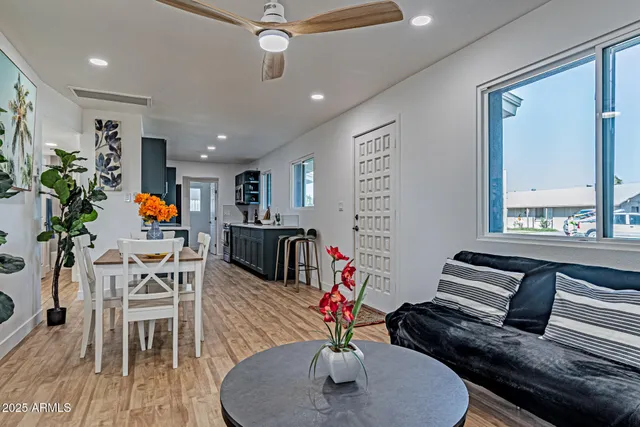 a living room with furniture kitchen view and a large window