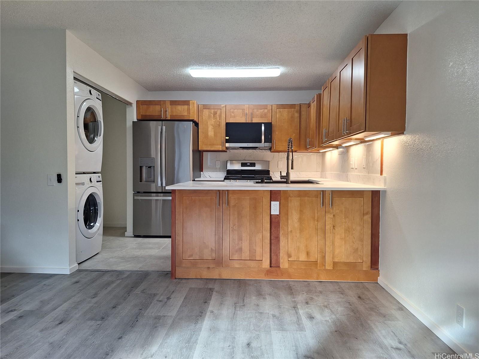 Undisclosed Address Ewa Beach, HI 96706 - Photo 2 of 11 a kitchen with stainless steel appliances granite countertop a refrigerator a sink a stove and a wooden floors