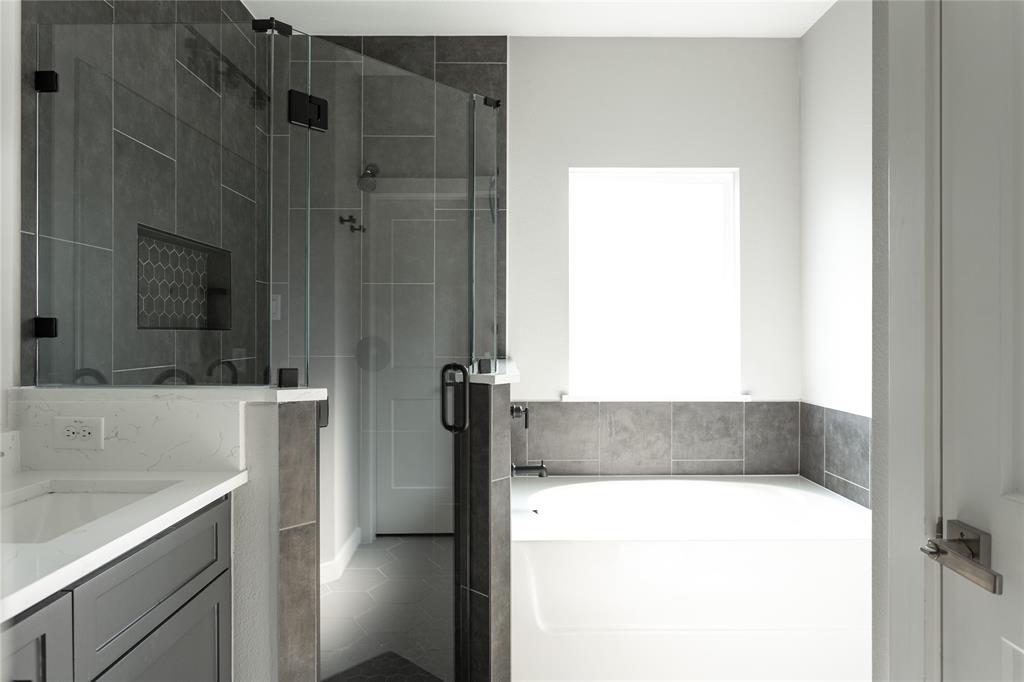 1108 Claude Street Dallas, TX 75203 - Photo 14 of 17 Full glass shower enclosure with dark gray subway tile and hexagonal accent niche